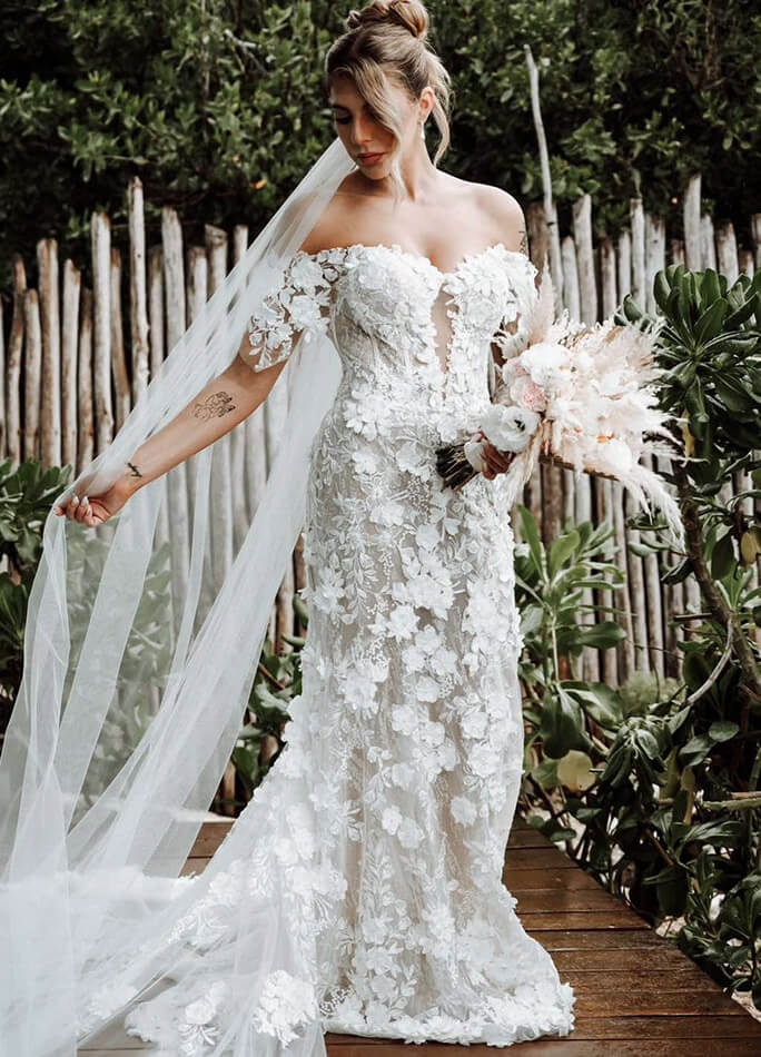 Model wearing a white gown with flowers